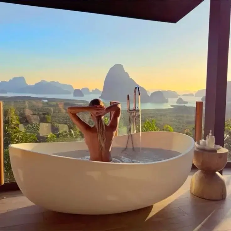 Блондинка моется в ванной с видом на море