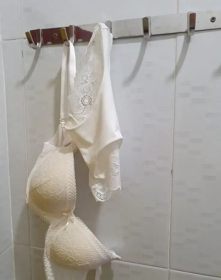 Девушка повесила трусики и лифчик на вешалку в ванной