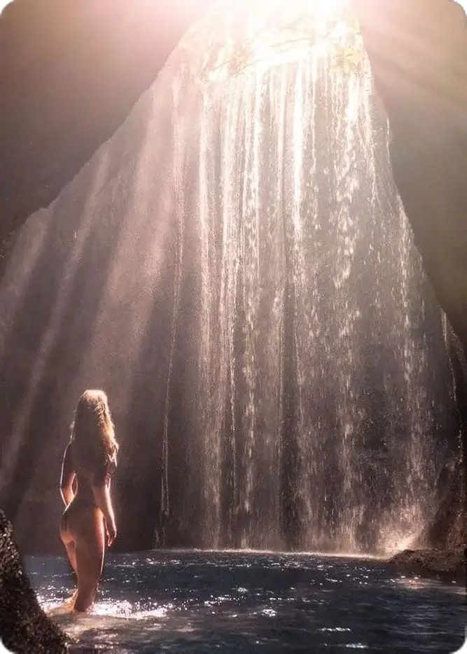 Девушки в бикини позируют возле водопада