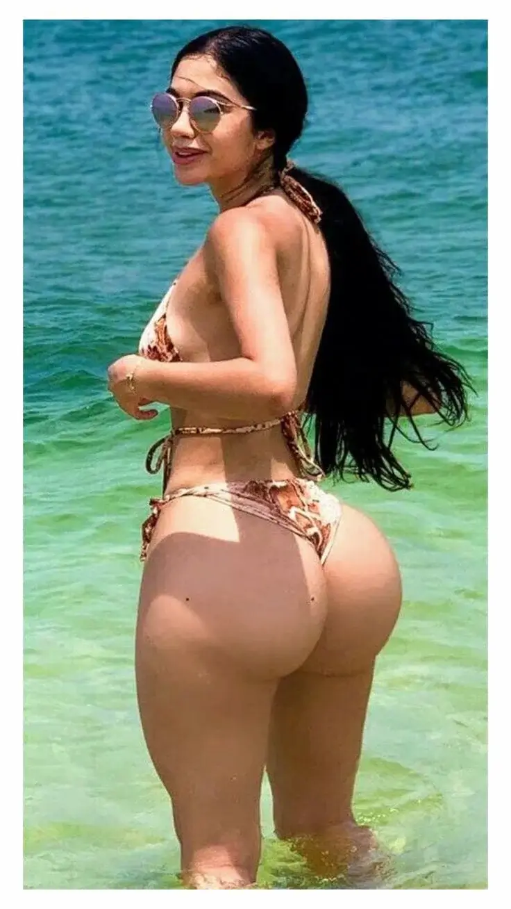 Мулатка с большой попой в купальнике стоит по колено в воде